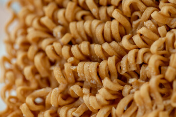 dried Instant noodles on white mulberry paper background. Instant noodles and pasta are wheat flour products call junk convenience food. Chinese and Japanese oriental noodle.