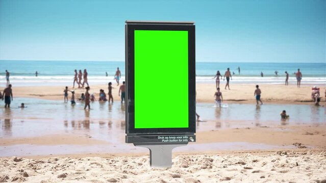 Digital Panel Green Screen Sand Beach People Walking Background Sunny Day. Vertical digital panel green screen standing on a sand beach with many people on a sunny day