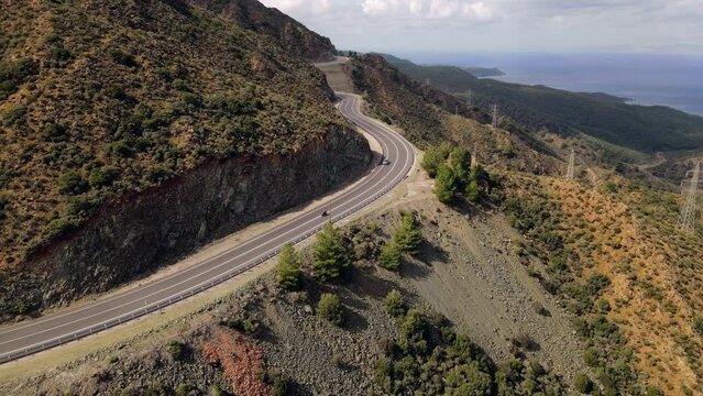Aerial view riding motorcycle on sunny winding road mountain pass