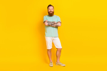 Full length portrait of nice satisfied glad young man crossed arms posing isolated on yellow color background