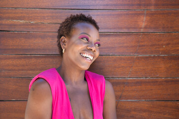 Young and beautiful Afro American woman doing different postures and expressions on a wooden background. The woman is smiling, sad, happy, joyful. Concept different postures and expressions.