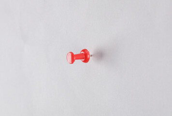 Red pushpin pinned on a gray background