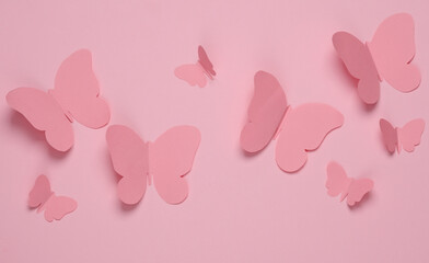 Butterflies cut out of paper on a pink background. Spring background