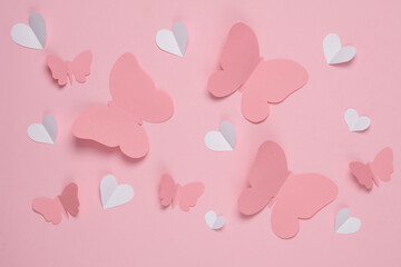 Butterflies and hearts cut out of paper on a pink background. Spring background, love concept....