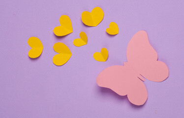 Butterfly and hearts cut out of paper on purple background. Love concept. Creative layout
