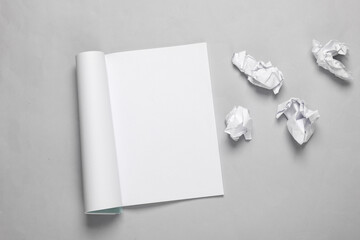 Notebook with torn crumpled sheets of paper on gray background