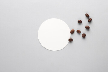 Mockup of white round coaster and coffee beans on gray background. Template for design