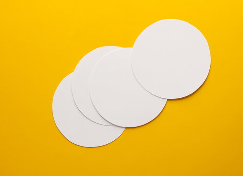 Mockup of white round coasters on yellow background. Template for design
