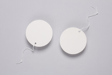 Round empty white price tags with string on gray background. Template for design