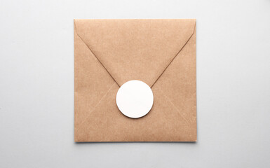 Kraft envelope with a white round label on a gray background. Template for design