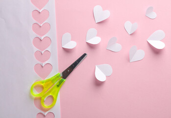 Paper-cut white hearts with scissors on a pink background. Love, romantic, valentine's day