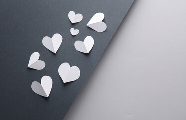 Paper cut white hearts on black and gray background. Love concept. Creative layout. Minimalism composition