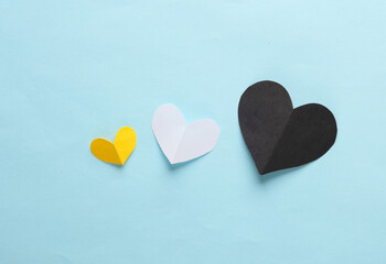 Paper-cut hearts on a blue background. Love concept