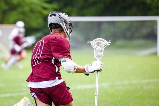 Closeup of a lacrosse player running in a sports field