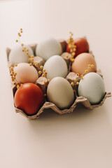 fresh chicken eggs of natural shades and colors in a recycled box on a white background. Easter concept