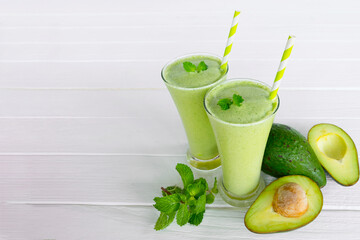 Kiwi yogurt fruit juice smoothie and green kiwi juice drink healthy, delicious taste in a glass for weight loss on a white wooden background.