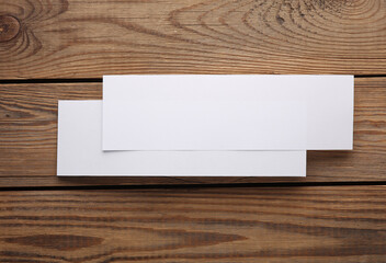 Mockup of two white blank tickets or flyers on wooden background. Template for design