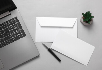 Creative business layout from white envelope with a letter and laptop on a gray background. Template for design