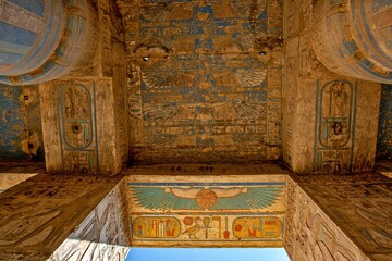 Interior of an Egyptian temple ceiling with colorful paintings and hieroglyphs