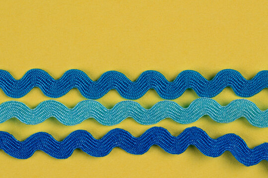 Closeup bunch of wave blue ribbons on yellow background