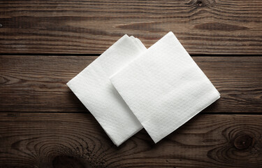 White napkins on a wooden table. Top view - obrazy, fototapety, plakaty