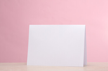 Pack of white paper desk calendar or announcement on the table, pink background