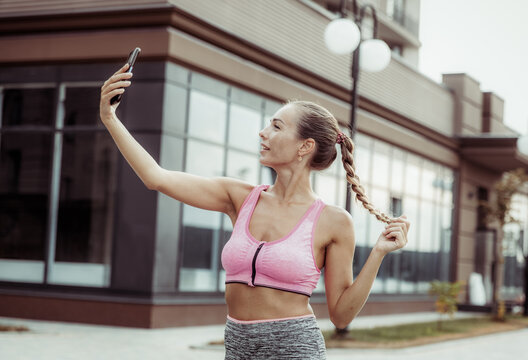 Fit woman makes selfie on the phone outdoors. Active lifestyle