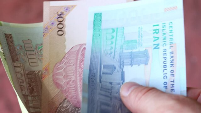 Iran currency, hand counting money, close up