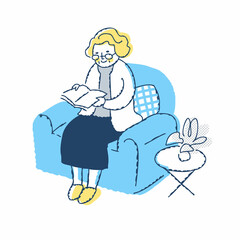 ソファーに座って本を読むシニア女性