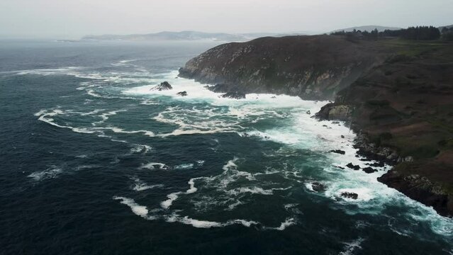 Panoramic View Of Ocean Waves Hitting Rocky Cliffs Near Coastal Park In Caion Beach, Coruna Spain. Aerial Drone Shot