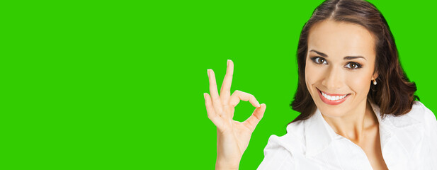Businesswoman in confident cloth showing ok okay hand sign gesture, over blurred modern office...