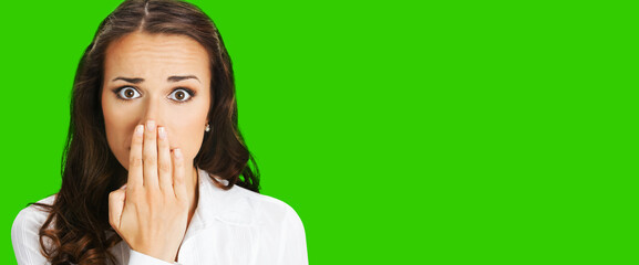 Unbelievable news! Excited surprised, shocked businesswoman, indoors. Young business woman covering mouth by her hand, isolated green chroma key background