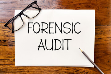 Forensic audit handwriting text on blank notebook paper on wooden table with pencil and glasses...