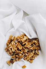 A pile of walnuts on a white material 