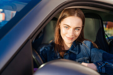 Beautiful young lady happy car. Cute girl who drives car and smiles. Portrait of happy woman...