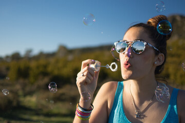 Attractive woman blowing soap bubbles