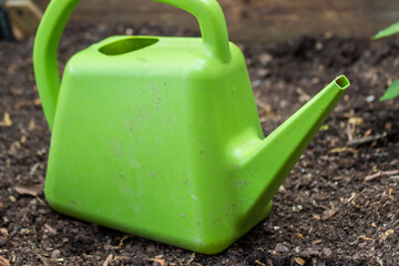 green watering can in the garden