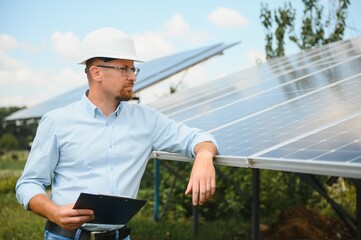 Solar energy. Young business man near the solar panels to power plants.