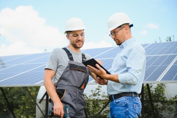 near the solar panels, the employee shows the work plan to the boss.