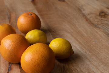 Warm orange-yellow brown background with citrus fruit oranges and lemons on a vintage wooden table. Health concept. Citrus fruits help with weight loss, skin ageing, boost immunity, heart diseases