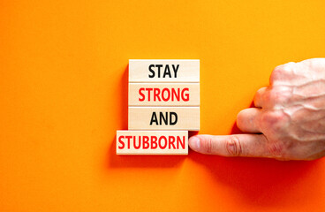 Stay strong and stubborn symbol. Concept words Stay strong and stubborn on wooden block. Beautiful orange table orange background. Motivational business stay strong and stubborn concept. Copy space.