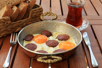 Turkish breakfast food, sahanda sucuklu yumurta , Turkish omelette with sucuk, tea and bread 