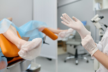 Doctor gynecologist wearing sterile rubber preparing for examination - obrazy, fototapety, plakaty