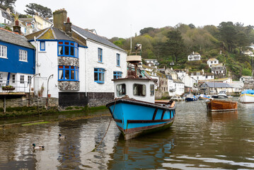 Fototapeta na wymiar View of the pretty historic Cornish fishing village of Polpero with the harbor, fishing boats and fisherman's cottages in Devon UK