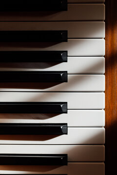 Closeup Of Black And White Pianos Keys On Wooden Baby Grand Piano In The Sun