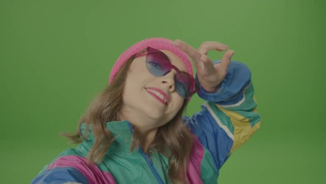Green Screen. Smiling Girl of '80-'90s Style With Pink Hat and Sunglasses Making Selfie, Poising at Camera. Concept of Teenager and the Internet, Blogger Girl