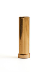 brass, golden lipstick tube against white background