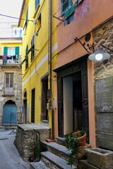 Fototapeta na wymiar Straßenscene mit bunten Häusern in einem ligurischen Dorf, Italien.
