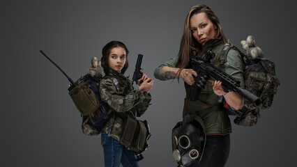 Fototapeta na wymiar Studio shot of post apocalyptic woman and young girl against gray background.