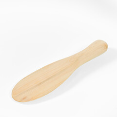 Wooden kitchen utensils. Wooden spatula for mixing salad on the background of a white mirror